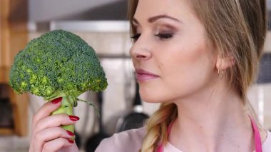 Ham yeşil sebze brokoli tutan mutlu genç kadın. Doğal organik sağlıklı gıda kavramı.