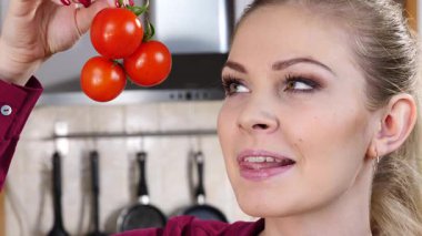 Küçük vişneli domates yiyen, sağlıklı yemek yiyen ve diyet yapan neşeli kadın..