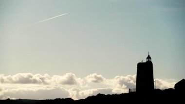 Güneşli bir günde deniz feneri karbonerasının üzerinde hareket eden bulutlar, la alcaidesa, Adalusia. İspanyol Akdeniz Kıyısı.
