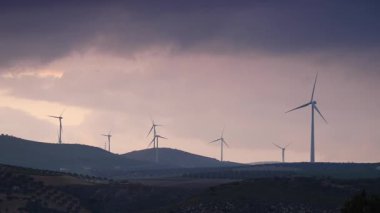Gün batımında tepelerde rüzgar türbinleri. Ardales, Malaga ili, Endülüs İspanya yakınlarındaki yenilenebilir enerji üretimi için enerji jeneratörü çiftliği.