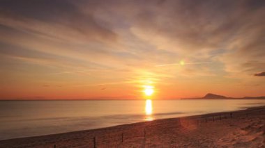 Sabahın erken saatlerinde denizde hareket eden bulutların hızlanması, güneşin doğması. Doğa manzarası. Gandia Sahili, Valencia İspanya.