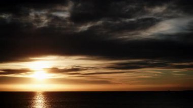 Sabahın erken saatlerinde deniz manzarası. Gün doğumunda denizin üzerinde hareket eden kara fırtınalı bulutların hızlanması. İspanya 'daki doğa manzarası.