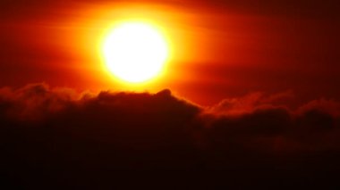 Gün doğumunda kara bulutlu, yakıcı kırmızı güneş. Sabah gökyüzü.