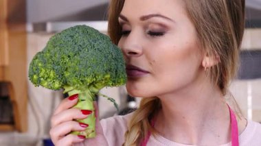 Ham yeşil sebze brokoli tutan mutlu genç kadın. Doğal organik sağlıklı gıda kavramı.