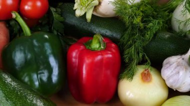 Mutfak masasında yavaş çekimde yakalanan çeşitli sağlıklı sebzeleri kapatın. Doğal beslenme konsepti..
