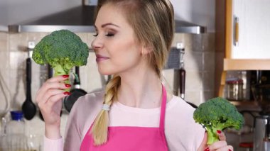 Ham yeşil sebze brokoli tutan mutlu genç kadın. Doğal organik sağlıklı gıda kavramı.