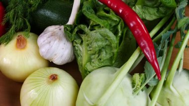 Mutfak masasında yavaş çekimde yakalanan çeşitli sağlıklı sebzeleri kapatın. Doğal beslenme konsepti..