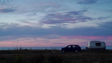 Deniz kıyısında kamp yapan karavan karavanıyla birlikte kıyı arazisinde bulutların hızlanması. Capicorb, Valencia bölgesi İspanya. Gezici evle tatil.