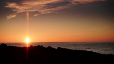 Sabahın erken saatlerinde deniz manzarası, deniz suyundan doğan güneş. Yanan turuncu gökyüzü. İspanya 'da doğa manzarası. Zaman penceresi