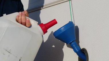 Karavan su deposunu huni kullanarak dolduran kişiyi kapatın. Karavanla seyahat ediyorum. Karavan tatili. Yavaş çekim