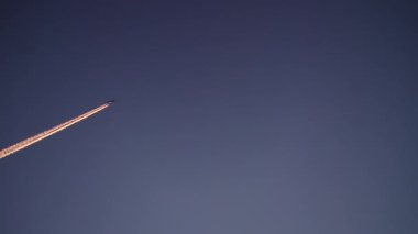 Akşam gökyüzünde uçan bir uçak. Seyahat