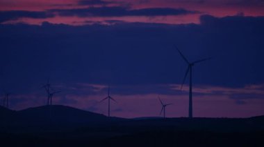 Akşam karanlığında tepelerde rüzgar türbinleri. Ardales, Malaga ili, Endülüs İspanya yakınlarındaki yenilenebilir enerji üretimi için enerji jeneratörü çiftliği.