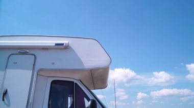 Karavanın üzerinde hareket eden beyaz bulutlar doğada kamp yapıyor. Karavanla seyahat ediyorum. Karavan tatili.