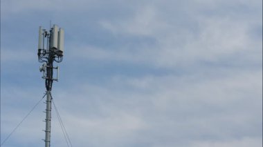 Telekomünikasyon kulesinin üzerinde 4G veya 5G hücresel ağ anteniyle hareket eden bulutların zaman akışı. Yeni mobil yayın teknolojisi üretimi.