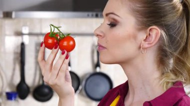Küçük vişneli domates yiyen, sağlıklı yemek yiyen ve diyet yapan neşeli kadın..
