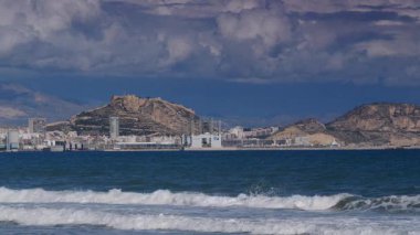Alicante, valencia, İspanya - 5 Aralık 2019: Benacantil Dağı 'ndaki Santa Barbara Kalesi' nin uzak mesafesinden Akdeniz manzarası. İspanya, Costa Blanca. Deniz dalgaları ağır çekimde hareket ediyor.