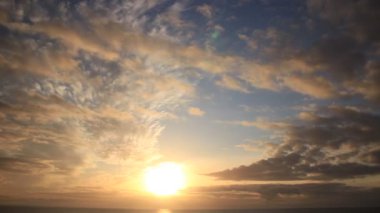Sabahın erken saatlerinde deniz manzarası. Bulutların zaman akışı denizde hareket ediyor ve güneş doğuyor. İspanya 'daki doğa manzarası.