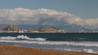 Alicante, valencia, İspanya - 5 Aralık 2019: Akdeniz kıyısında, Santa Barbara Kalesi ve deniz kıyısında Benacantil Dağı 'nda. İspanya, Costa Blanca. Deniz dalgaları ağır çekimde.