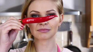 Kırmızı kırmızı biber bıyıkmış gibi davranarak eğlenen komik kadın. Sağlıklı gıda ve diyet konsepti.