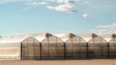 İspanya kıyılarında büyük ticari cam seralar ile hareket eden bulutların zaman akışı. Endüstriyel tarım. Murcia bölgesi, İspanya.