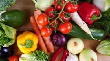 Mutfak masasında yavaş çekimde yakalanan çeşitli sağlıklı sebzeleri kapatın. Doğal beslenme konsepti..