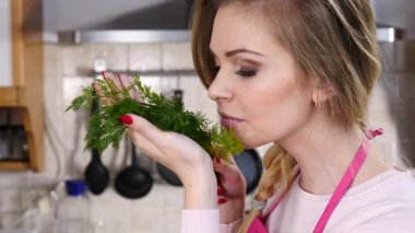 Yeşil dereotlu sebze kokusu alan genç ve güzel bir kadın. Sağlıklı gıda kokusu kavramı.