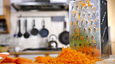 Izgarayı ve doğranmış havucu yavaş çekimde mutfak tahtasına yakın tut..