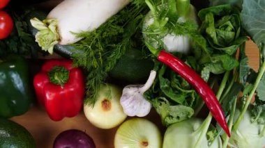Mutfak masasında yavaş çekimde yakalanan çeşitli sağlıklı sebzeleri kapatın. Doğal beslenme konsepti..