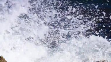Büyük dalgalar kayalıklara çarpıyor. Ağır çekim. Yukarıdan görüntüle