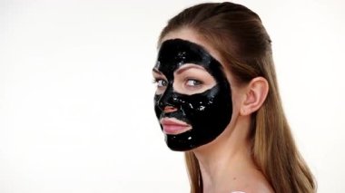 Yüzünde, beyaz karbonhidrat temizleme maskesi olan genç bir kadın. Genç kız yağlı cildiyle ilgileniyor, gözenekleri temizliyor. Güzellik tedavisi. Cilt bakımı.