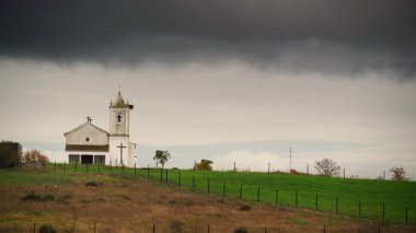 Evora, Portekiz 'deki Luz köyünde küçük bir kilisenin üzerinden geçen şiddetli yağmur bulutları..