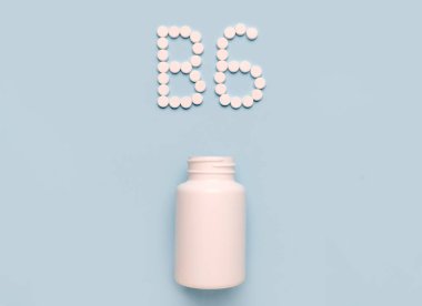 B6 vitamini, Pyridoxine, tabletlerden ikon ve mavi arka planda ilaç şişesi. Vitamin ve minerallerin çarpışması 