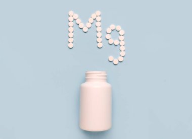 Mavi arka planda haplardan ve ilaç şişesinden kimyasal element Magnezyum MG simgesi. Vitamin ve minerallerin çarpışması 
