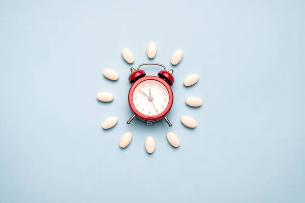 薬を飲む時間だ 時計は青の背景に白い錠剤から作成されました 医薬品の使用に適した時期 — ストック写真