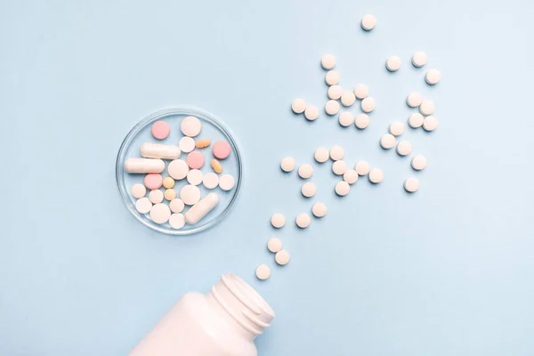 Egy Fehér Üvegből Kiömlött Gyógyszerek Egészséges Orvostudományi Koncepció Kék Alapon — Stock Fotó