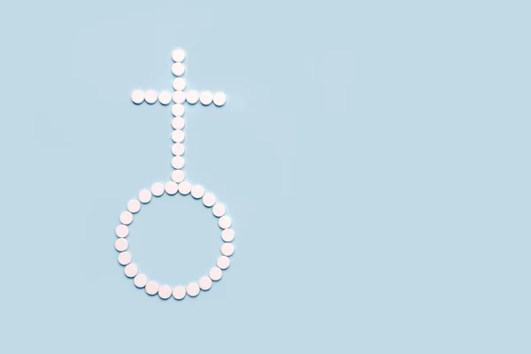 Medical pills in female symbol shape on a light blue background. Concept female  health, contraception,  pregnancy, fertility. Copy space