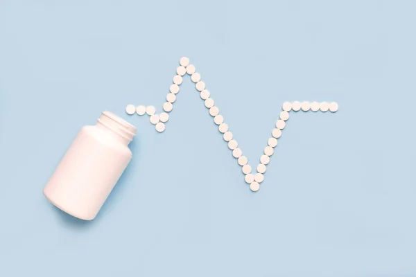 心臓と心臓の脈の形をした丸薬は白い瓶からこぼれた 医薬品 循環器学の概念 — ストック写真