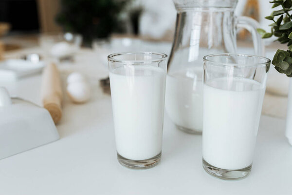 молоко в стакане на белом столе
