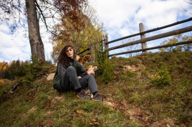Dağlarda köpeği olan genç bir kadın.