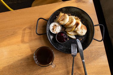 Lezzetli peynirli kekler, ekşi krema, çilek reçeli ve kahve.