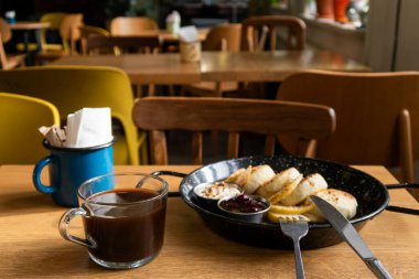 Lezzetli peynirli kekler, ekşi krema, çilek reçeli ve kahve.