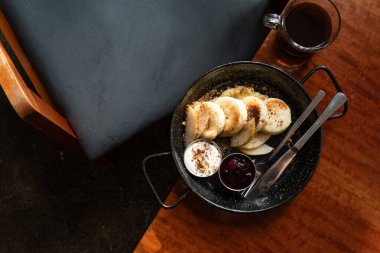 Lezzetli peynirli kekler, ekşi krema, çilek reçeli ve kahve.