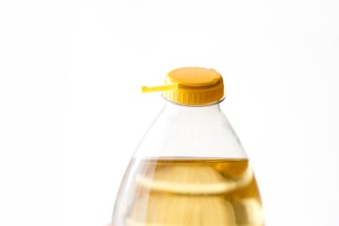 Beyaz arka planda izole edilmiş ayçiçeği yağlı PET şişesi için sarı plastik kapak. Daha az plastikle yeni tasarım. Plastik atıkları azaltmak için tasarlandı. 