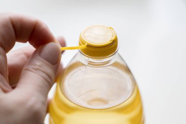 Beyaz arka planda izole edilmiş ayçiçeği yağlı PET şişesi için sarı plastik kapak. Daha az plastikle yeni tasarım. Plastik atıkları azaltmak için tasarlandı. 