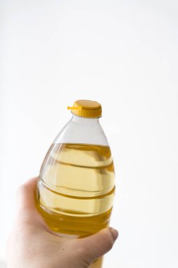 Beyaz arka planda izole edilmiş ayçiçeği yağlı PET şişesi için sarı plastik kapak. Daha az plastikle yeni tasarım. Plastik atıkları azaltmak için tasarlandı. 