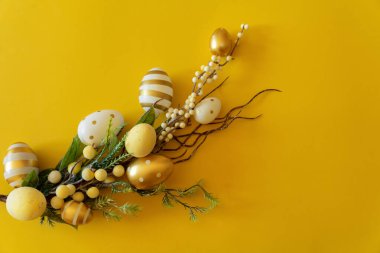  Sarı arka planda Paskalya yumurtaları olan bir dal. Metin için yeri olan Mutlu Paskalyalar