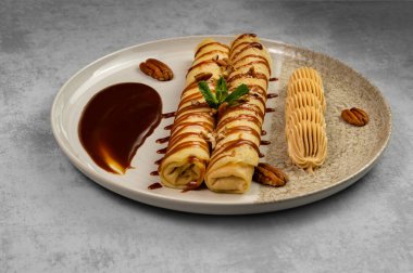 Çikolata kaplı krep ve gri arka planda fındık ezmeli tatlı. Pişirme ve pişirme.