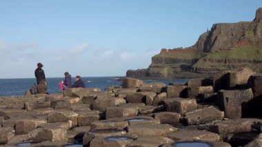 Devler Geçidi, Kuzey İrlanda, İngiltere - Kasım 05 2022: İnsanlar birbirine kenetlenmiş 40000 bazalt sütunun keyfini çıkarıyorlar.