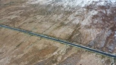 The R251 next to the snow covered Mount Errigal, the highest mountain in Donegal - Ireland