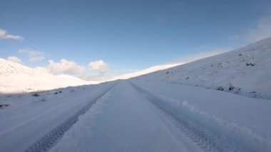 Driving through the snow covered Glenveagh National Park in the shadow of a mountain - County Donegal. Republic of Ireland.